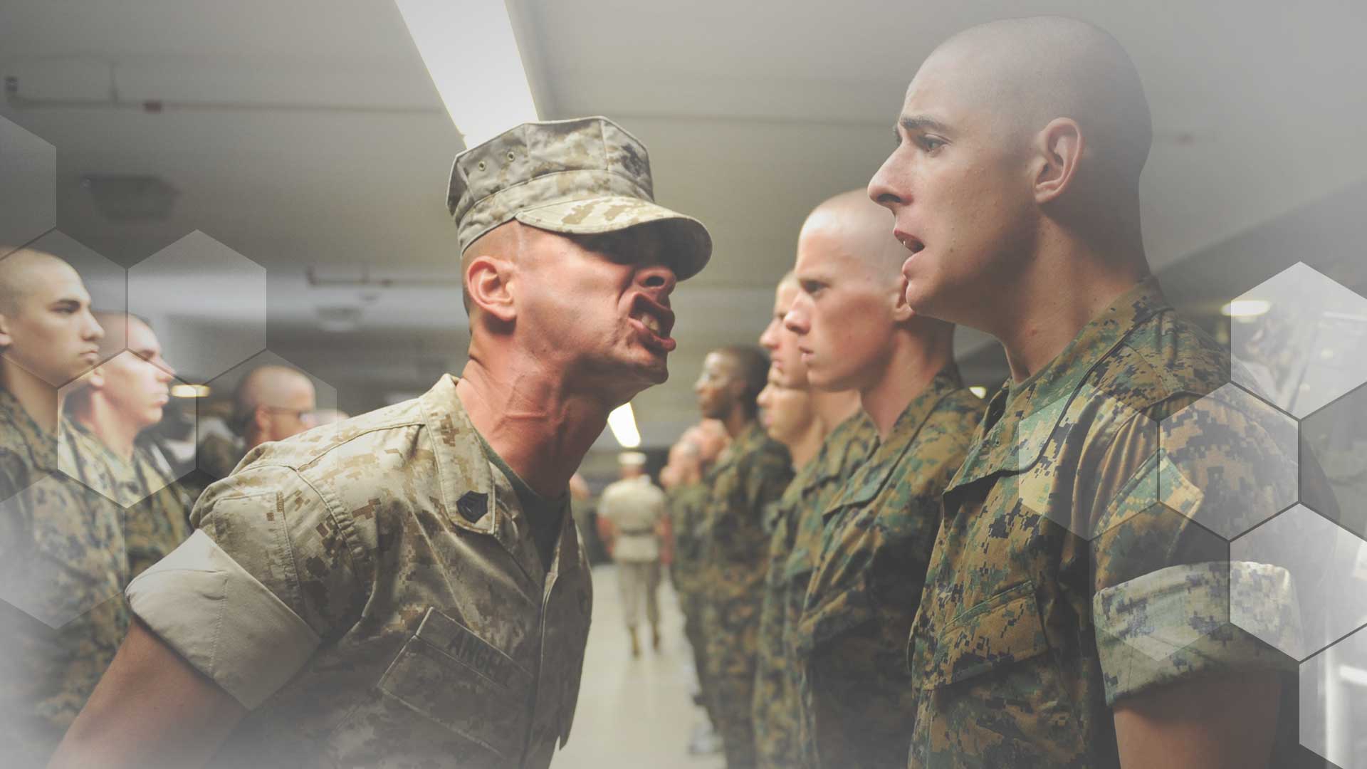 A drill sergeant yells at a hapless recruit in a line-up of troops.