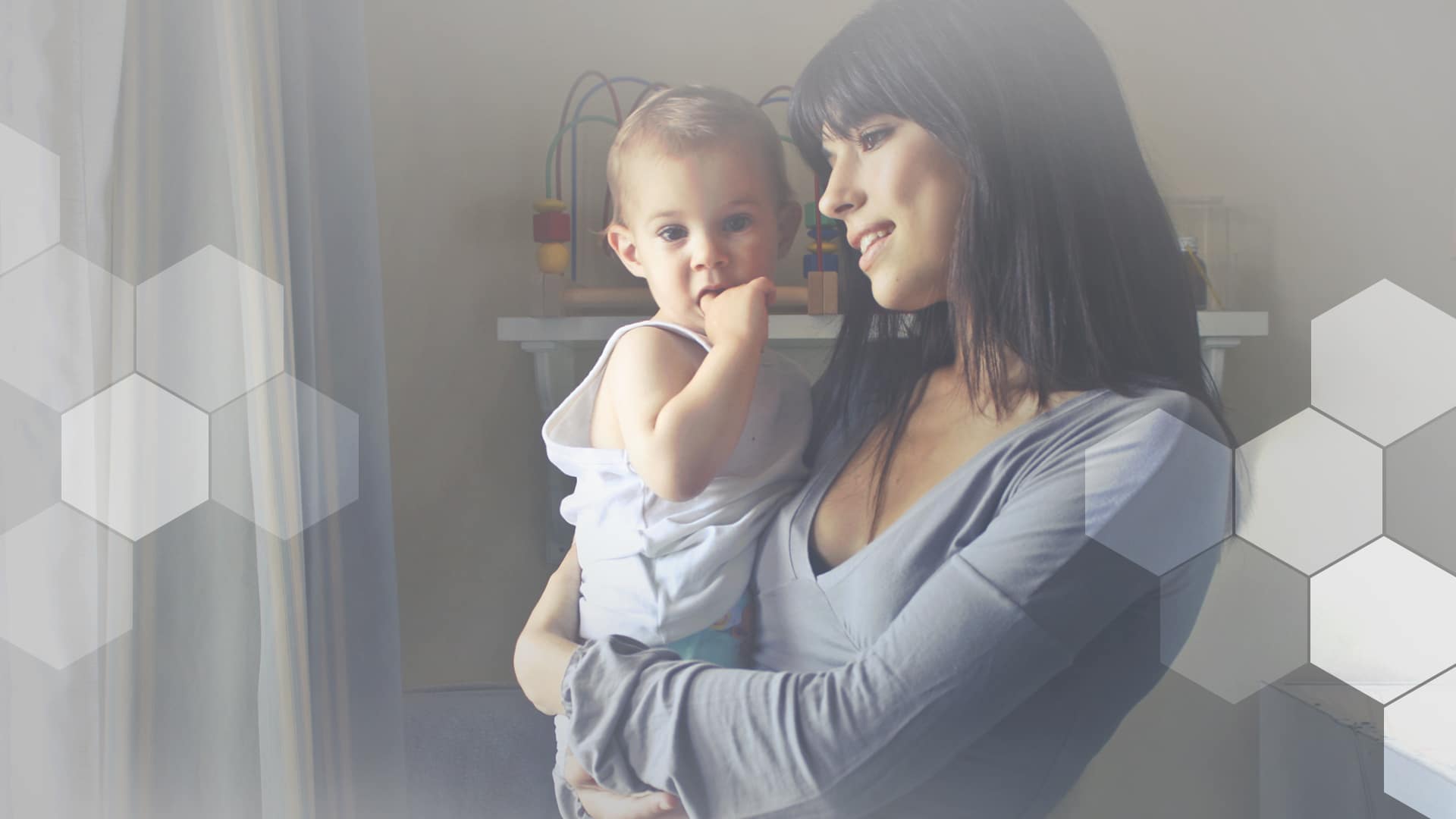 A happy woman holds her baby at home, totally vibing on the home-based agent model..